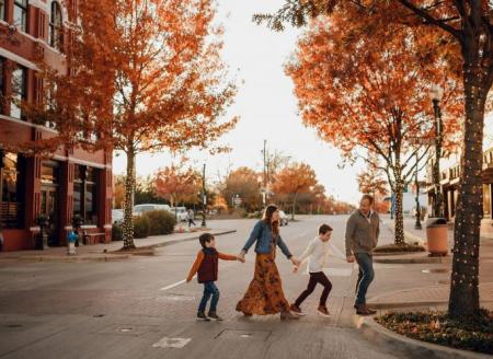 Family crossing the street in downtown Mckinney with fall leaves