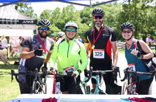 Four people in cycling gear smiling