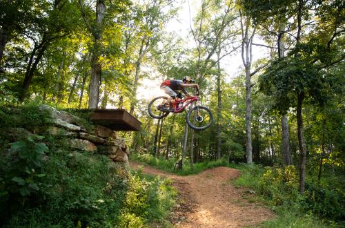 A man jumping off a large bike feature