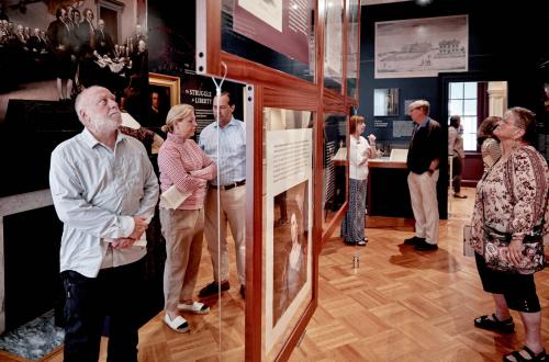 A group looking through an exhibit at morven museum