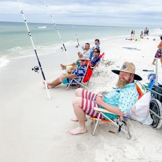 a group of guys sitting in beach chairs while shore fishing