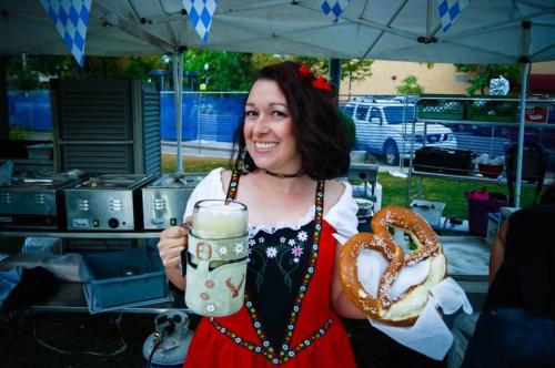 Woman holding a beer stein and pretzel at Oktobrewfest