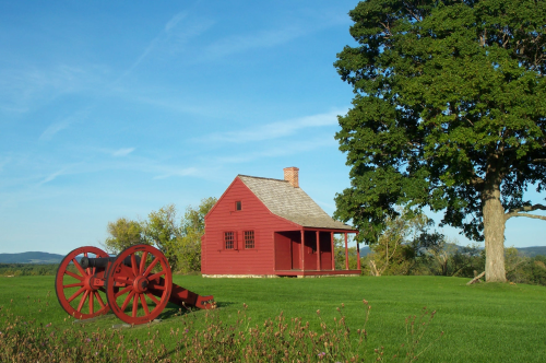 Red cabin and cannon on park grounds in the summer