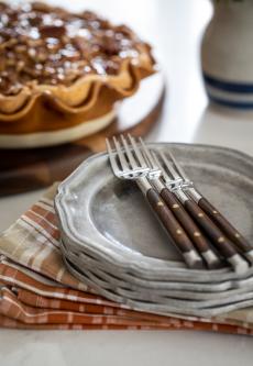 Stack of pewter plates with forks