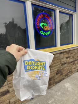 bag of donuts in front of donut sign