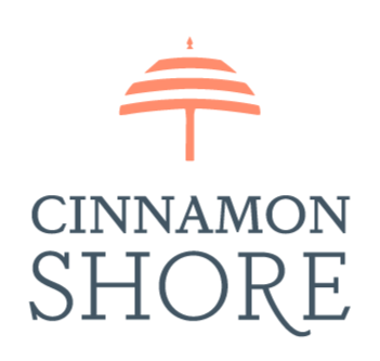 blue text reads Cinnamon Shore. Over top of it is the outline of an umbrella in orange.