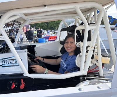 A Visit Delaware staff member sitting inside a speedway car.