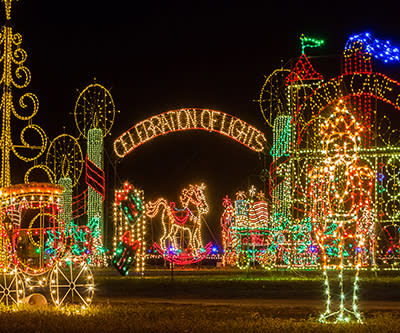 A display of creative lights spelling out "Celebration of Lights" is on an archway over the grounds at Meadow Lights.