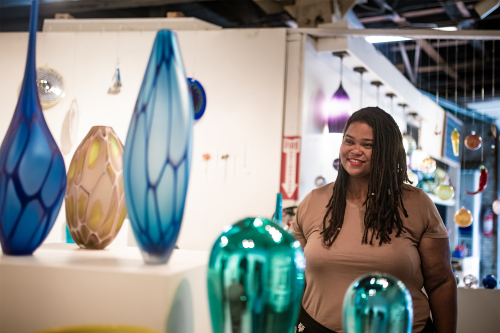 a person looking at handblown glass sculptures