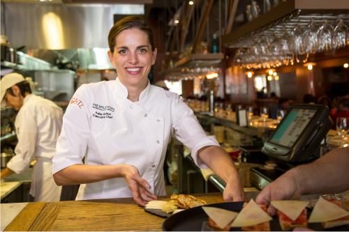 Katie Button serves food to waiter at Curate restaurant