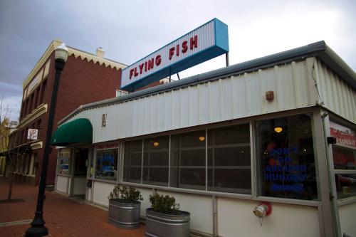 A white restaurant building with a sign that reads flying fish