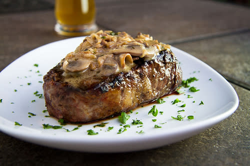 A perfectly cooked steak topped with creamy mushroom sauce, served at Little Bear Inn, one of the hidden gems in Cheyenne for delicious local dining experiences.