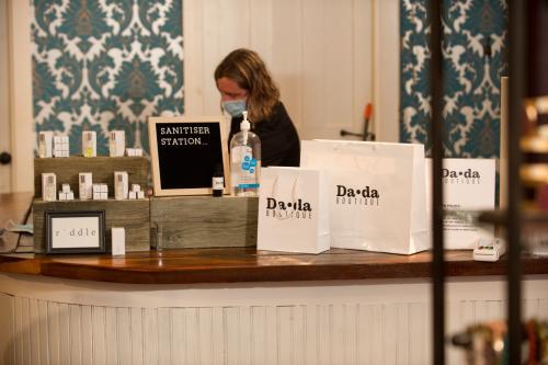 Woman in mask behind counter of DADA Shopping in Southern Indiana