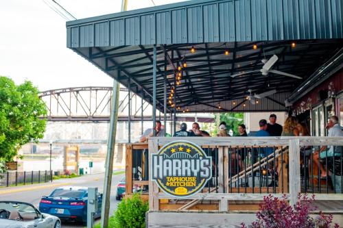 Exterior view of Harry's Taphouse with people sitting on the covered patio