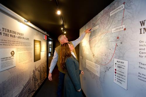A couple examining a large map display in the Carnegie Center for Art & History.