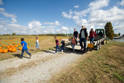 Family getting off of a tracker trailer at Joe Huber's to pick pumpkins