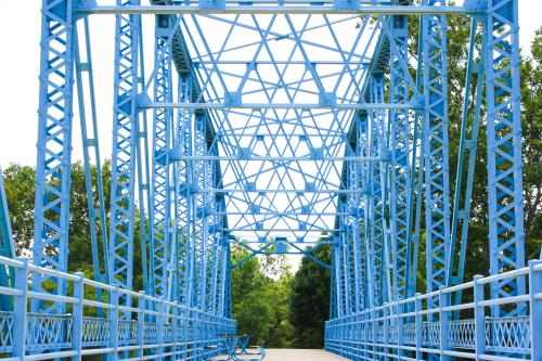blue bridge at the decatur county park with trees in the background