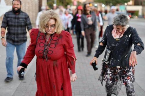 Women dressed as zombies walking on stone sidewalk