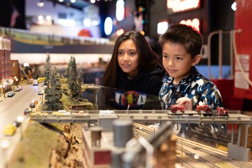 Two young people looking at a model train exhibit at the Colorado Model Railroad Museum