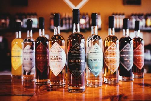 Product photos of 477 Distilling bottles on a wooden bar top