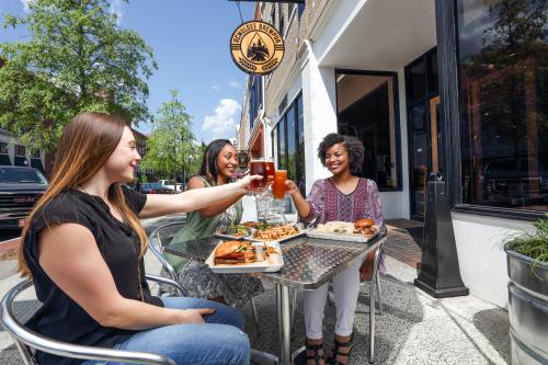 A group toasts to friendship over a meal on the patio at Ocmulgee Brewpub in Macon.