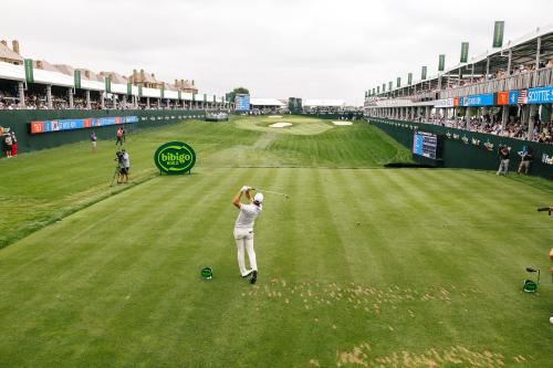 Man golfing on green in a tournament