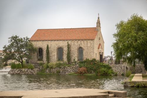 Historic wedding chapel surrounded by blue water and greenery