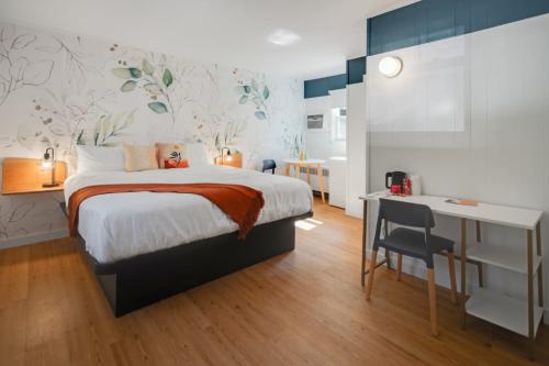 motel bedroom with comforting lighting, floral wallpaper, bed and desk