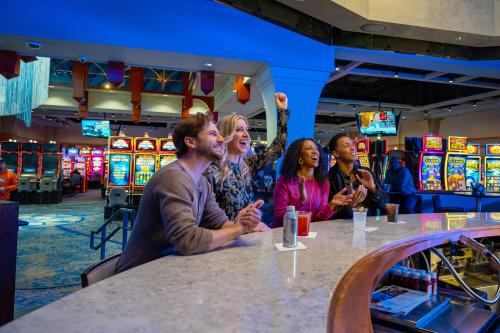 four people sitting at a bar in a casino