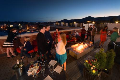 Group enjoying drinks and fire pit on the Pavilion Grand Hotel balcony in Saratoga Springs, NY at night