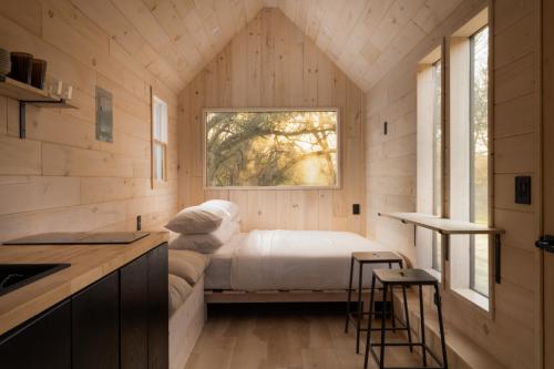 room in wood cabin with natural lighting, freshly made bed
