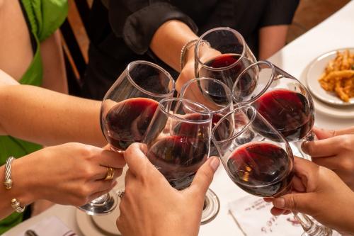 people cheering red wine around a table