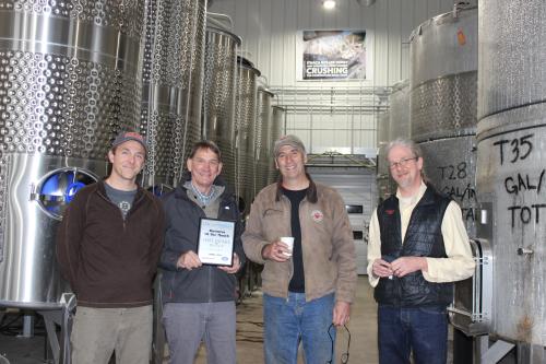 Staff from Sheldrake Point Winery Pose with the plaque awarding them the April 2021 Business of the Month Award.