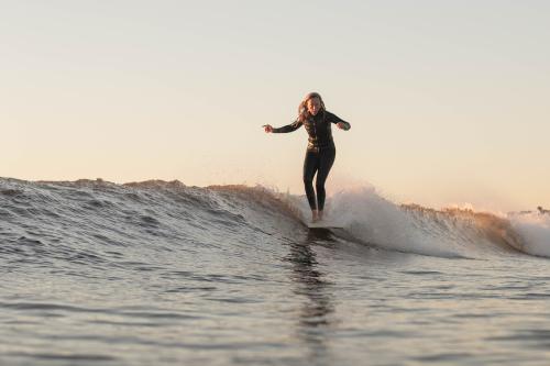 woman surfing in a black wetsuit