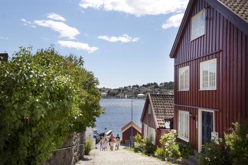 People walking among houses at Tyholmen in Arendal