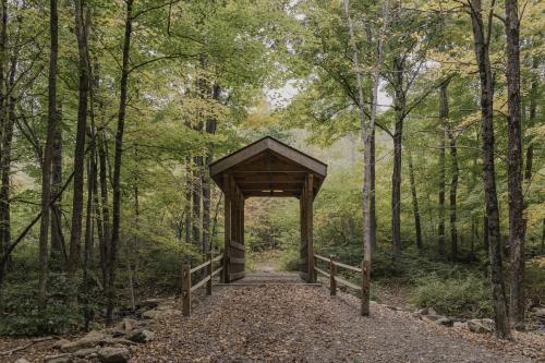 A leaf strewn path in front of a covered bridge on a trail at Ward Pound Ridge Reservation.