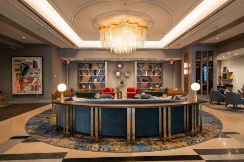 A seating area in a hotel lobby with bookshelves and a round-shaped sofa.