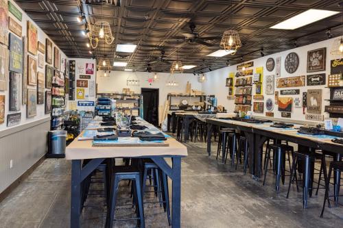 Inside the Board & Brush Woodbury Studio featuring long tables, stools and artwork.