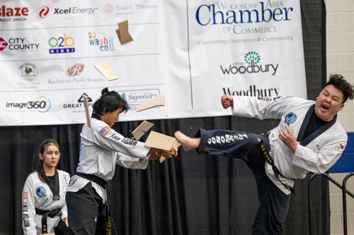 Martial artist demonstrates breaking a piece of wood with a strong kick