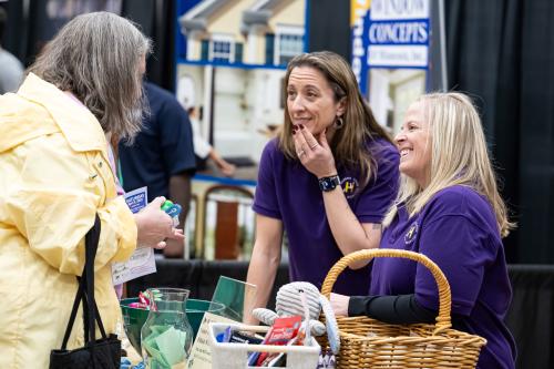 Exhibitors welcome an attendee to their booth at the Woodbury Community Expo