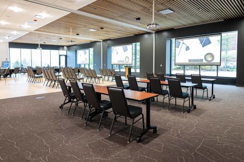 Meeting space shown with tables and chairs in Woodlands Room meeting space at Woodbury Central Park.