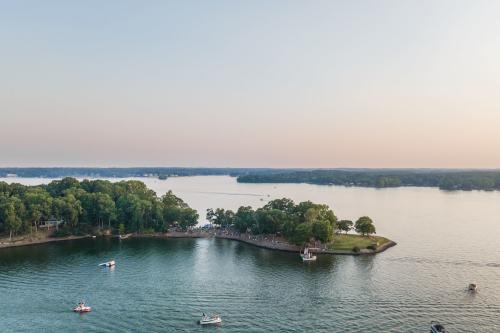A picturesque view of a like with boats on the water and a strip of land in the center of the lake extending to the left