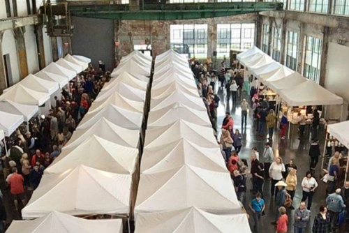 An aerial view of people walking around booths in the WaterFire Arts Center.