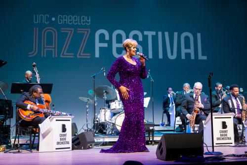 Women in purple dress singing with jazz band in the background at UNC Jazz Fest 2025