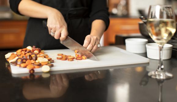Person chopping vegetables at New York Kitchen; Photo Credit: Grant Taylor Photography Person chopping vegetables at New York Kitchen; Photo Credit: Grant Taylor Photography