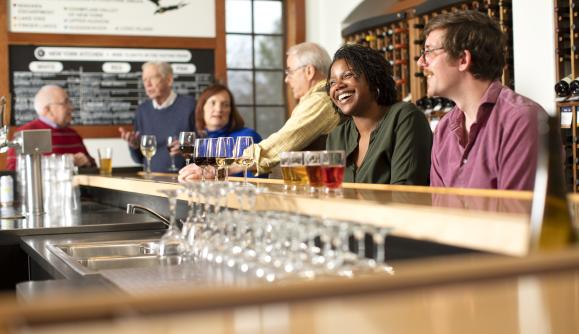 People drinking inside tasting room at New York Kitchen; Photo Credit: Grant Taylor Photography People drinking inside tasting room at New York Kitchen; Photo Credit: Grant Taylor Photography