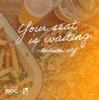 An image of pizza, French fries, and two frothy beers on a table at a brewery in Rochester, NY with the text "Your seat is waiting. -Rochester, NY" laid over it