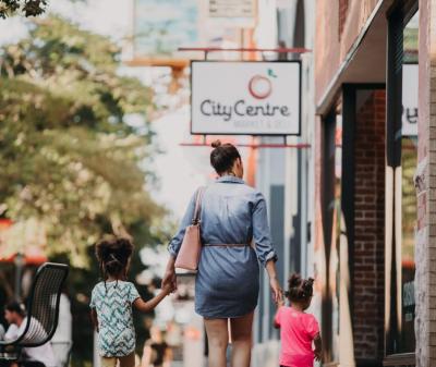 A woman and children walking down the sidewalk