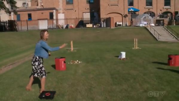 A woman plays a game in a grassy area