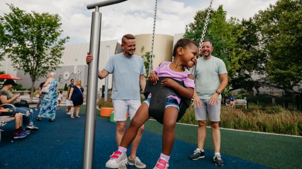 Couple and their daughter playing at Dorrian Commons outside of COSI.